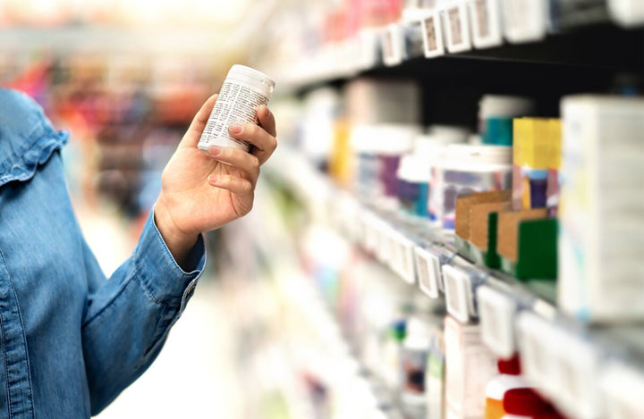 Shopper choosing a supplement in a pharmacy
